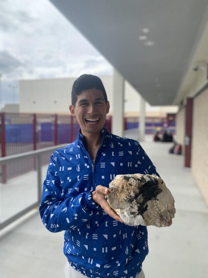 Mr. Ly poses with his infamous doorway rock to show his love for geology.