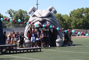 Our varsity football team emerges from the famous Bulldog inflatable in a showcase at our most recent rally. During the introduction, players held and displayed the Battle for the Bone trophy they had earned the year prior, hoping to keep it this year as well.