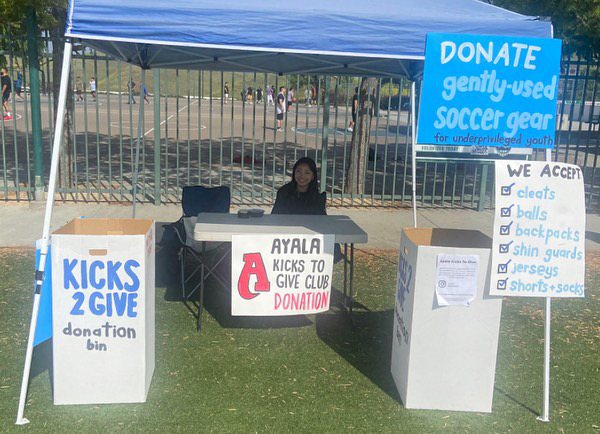 Laurie Park (12) is seen at one of the many donation events that Kicks2Give participates in. The club sets up stands with boxes that passing families can drop lightly-used soccer gear into. Hoping to receive a variety of donations, these events allow for Kicks2Give to extend their reach to the community and give a chance for local families to help children in need.