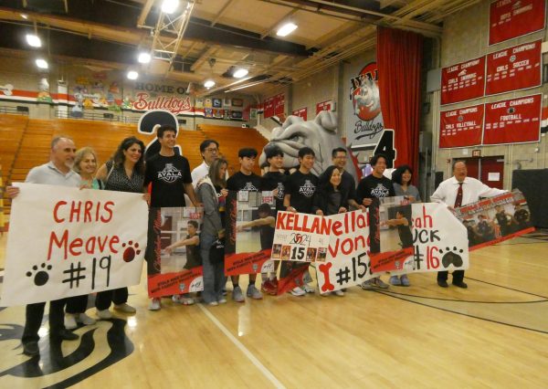 Seniors Chris Meave, Kazuki Kiuchi, Kellan Wong, and Micah Luck commemorated in front of the audience as their family join them on the floor with congratulatory posters.