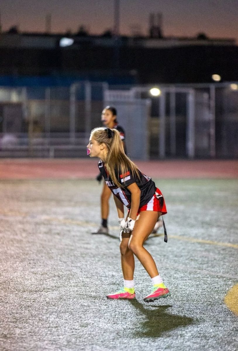 Ava Trujillo (9) prepares for the ball to be hiked so game play can begin. This was during the flag football game on August 27 where the Ayala Bulldogs played against the Quartz Hill Royals. Although a difficult game Ayala was able to prevail with a win. 