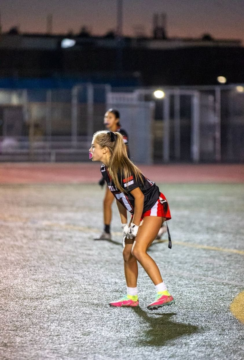 Ava Trujillo (9) prepares for the ball to be hiked so game play can begin. This was during the flag football game on August 27 where the Ayala Bulldogs played against the Quartz Hill Royals. Although a difficult game Ayala was able to prevail with a win. 