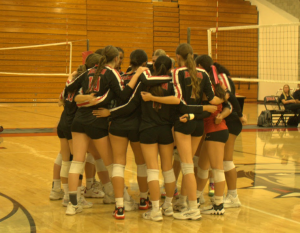 The Varsity team huddling together at their last game of the season against Bonita's Bearcats.