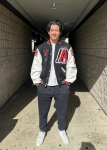 Senior Zachary Zheng in his letterman jacket covered with patches showcasing his accomplishments in football and academics.