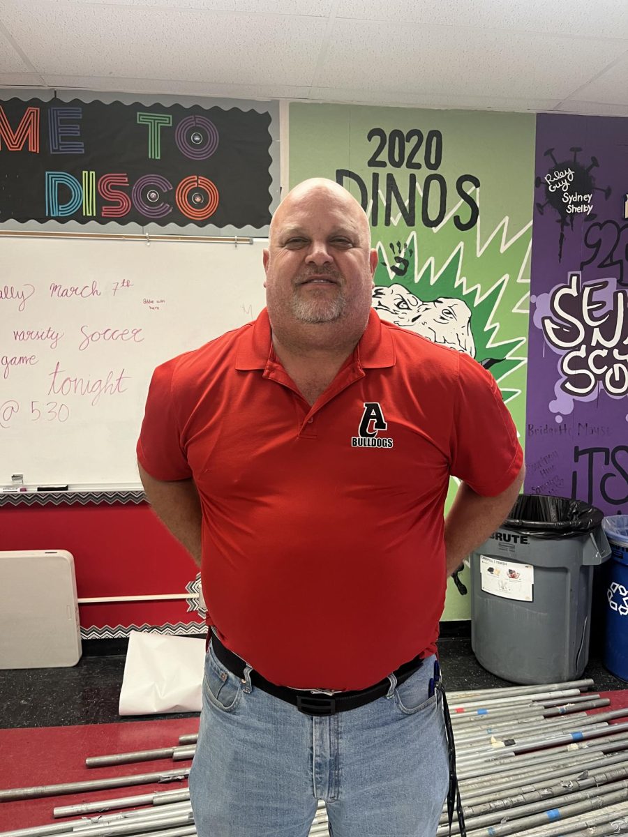 Mr. Reams poses in front of the posters representing the past classes, hoping to leave a similar legacy in the USB class by uniting the students and providing new ideas. 