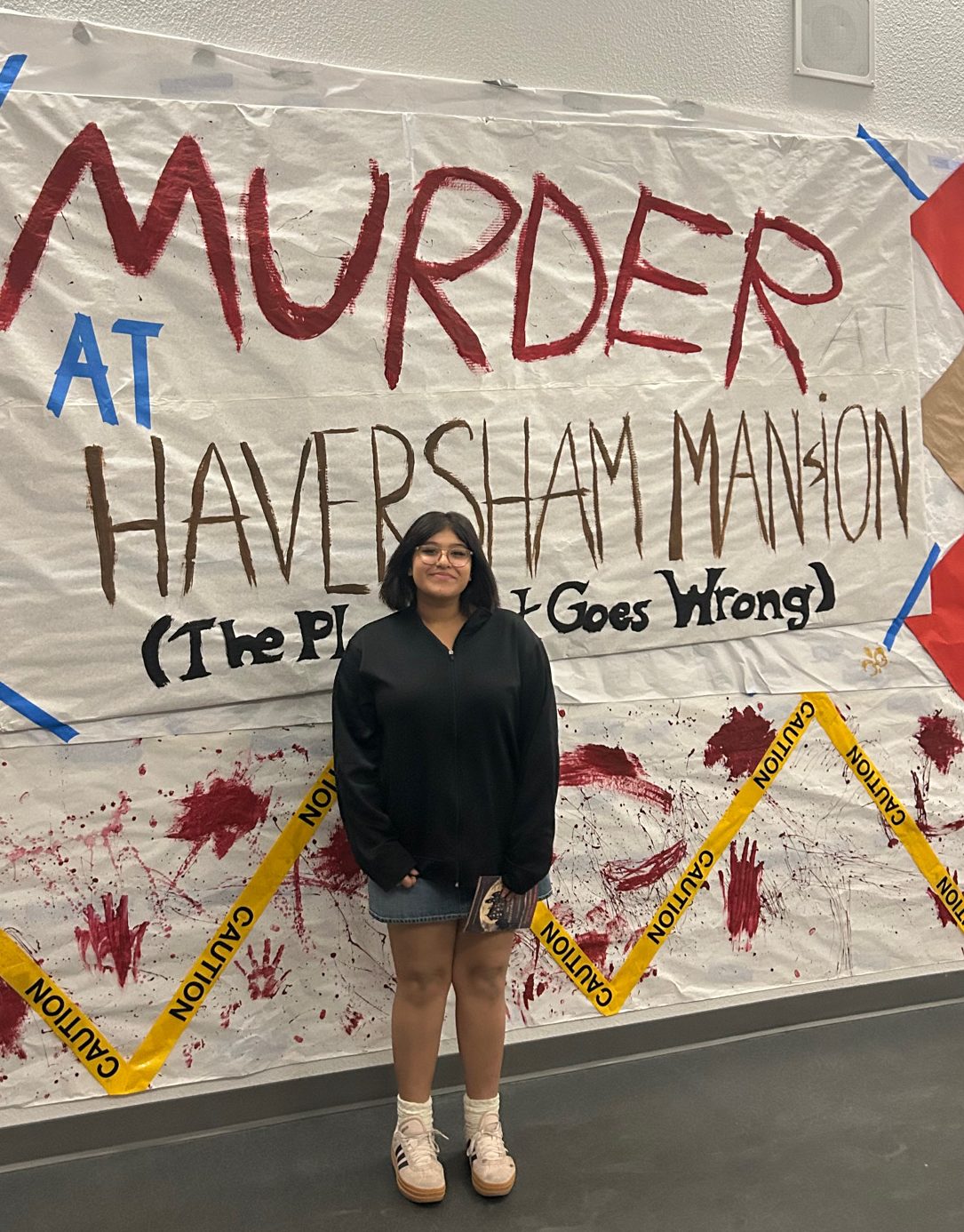 Luna Maciel (11) stands proudly in front of the poster she created for Ayala Theatre Company's Production of "The Play That Goes Wrong."