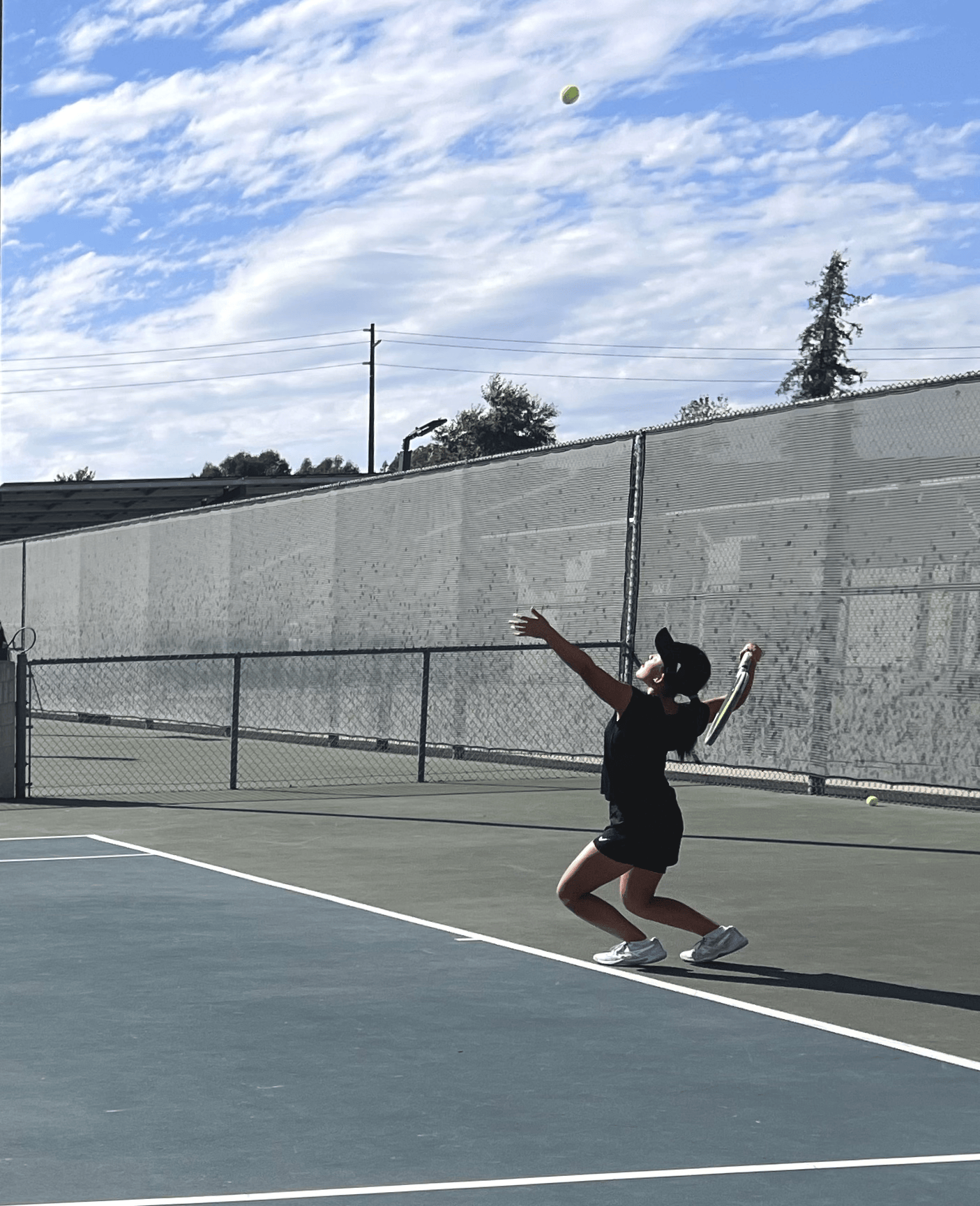 Hailey Liu (9) prepares to serve the ball before she gives it an energetic whack of her racket getting it over the fence starting the match. She serves for her match during Ayala's JV tennis match on 923 where unfortunately they lost with a 5-13 score. 