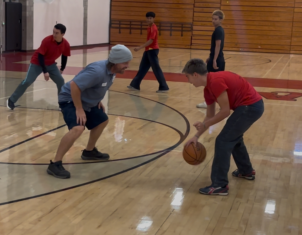 An isolation possession by a student basketball player, being guarded by one of the staff members of Ayala.
