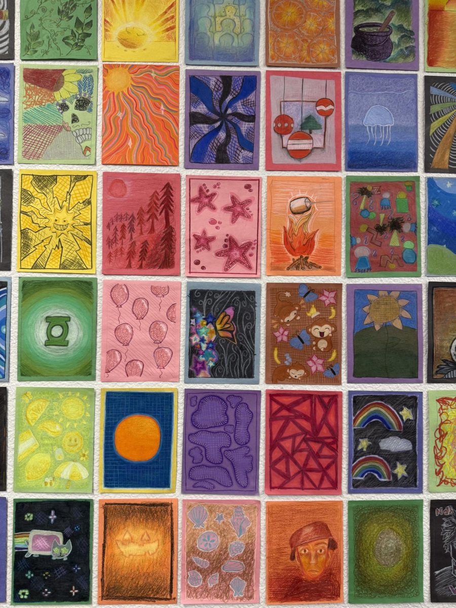 A wall-lined with color-specific drawings represents the feelings associated with their respective hue. Amongst the bright and abstract artworks, the thousand-yard stare stands out. The angst and despair in the soldier’s eyes outweighs the lighthearted Nyan Cat and swirls of color that surround it. 
