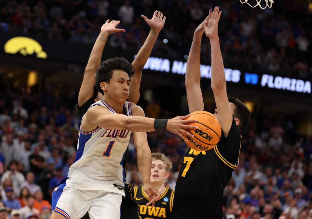 Florida Gators guard Xaivian Lee (1) passes the ball around Iowa Hawkeyes forward Alvaro Folgueiras (7) in the final seconds as Florida Gators was unable to get a shot off in the second half during a second round game of the men's 2026 NCAA Tournament at Benchmark International Arena.