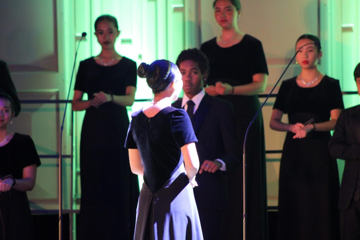 Student Director Madelene Lubangco (12) directs the Vocal Ensemble for one of her final performances with the song she both chose and taught as a tradition for being in this position. 